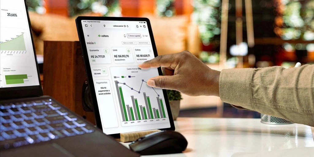 Close em mão mexendo no tablet na tela inicial de um sistema de gestão de energia