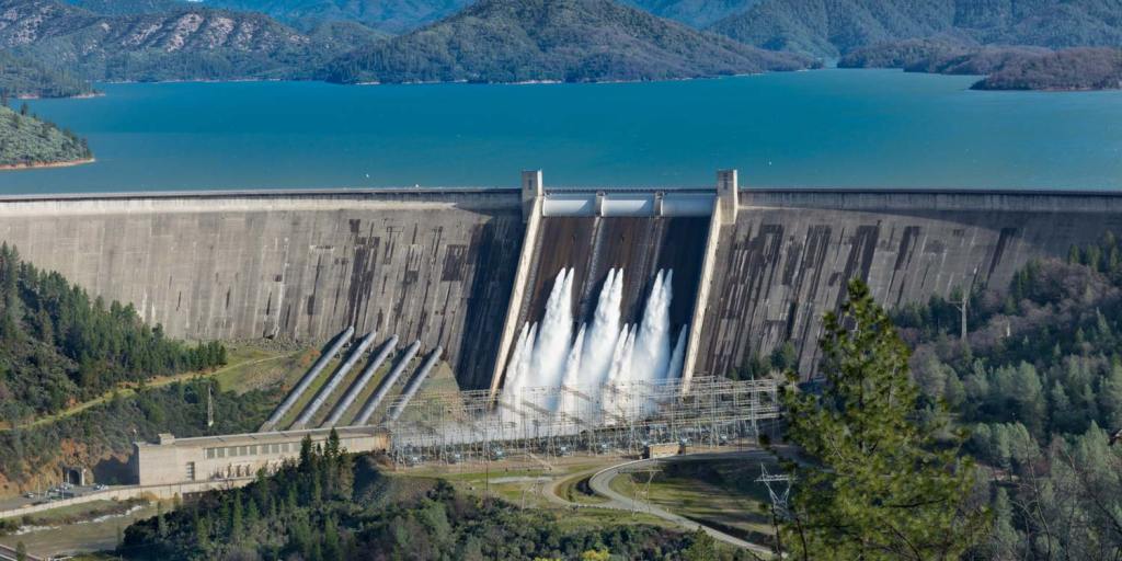 Barragem hidrelétrica com água vertendo, ilustrando o nível dos reservatórios e seu impacto na geração de energia